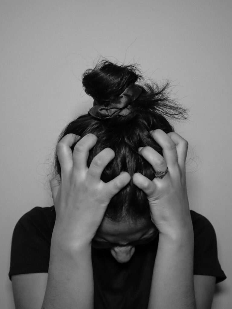 Woman with hands on her head.