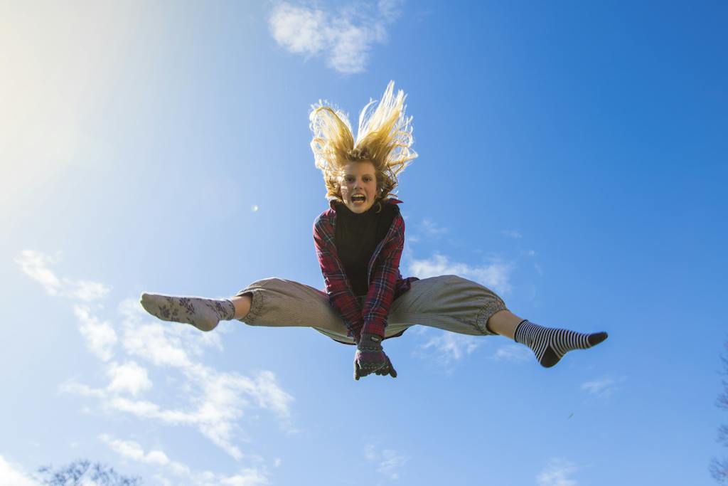 Woman Jumping Under Blue Sky